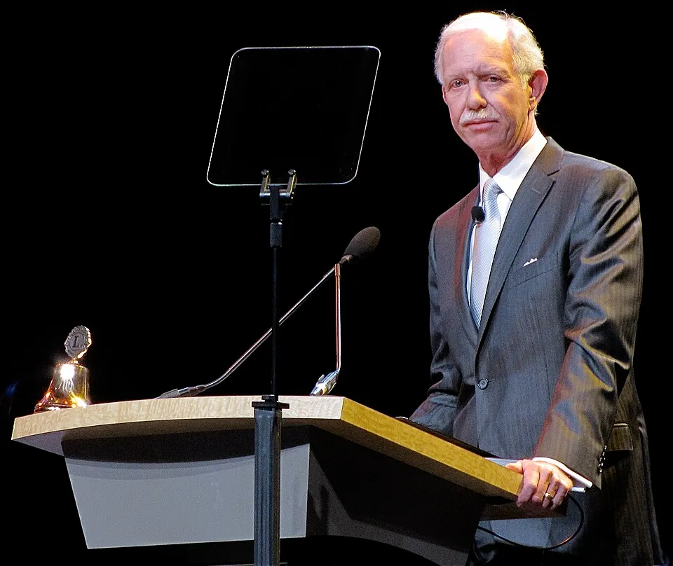 Chesley Sullenberger, cu părul alb și mustață, vorbind la un pupitru, pe o scenă la Sydney