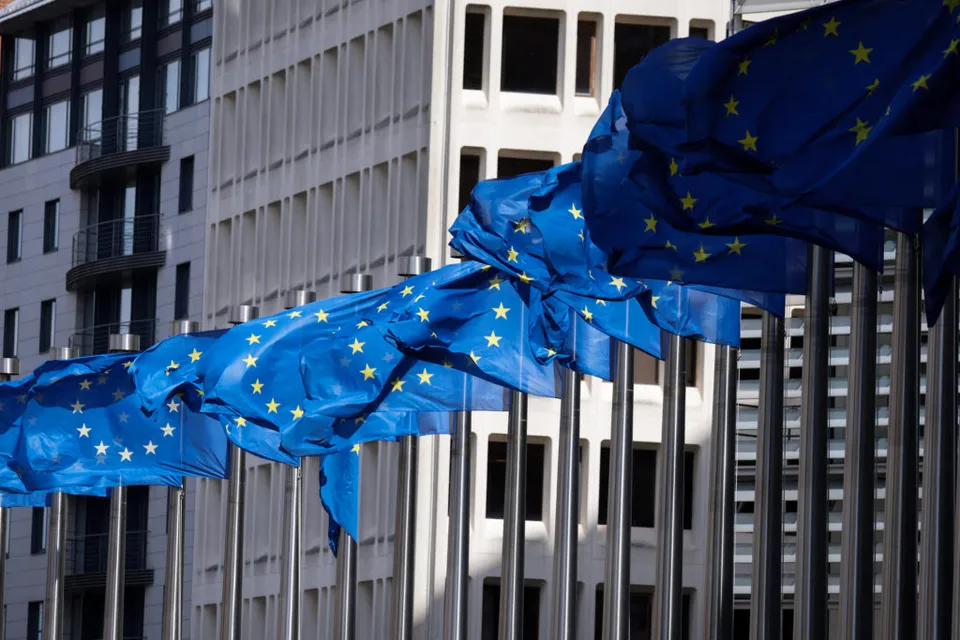 Drapele ale Uniunii Europene fluturând în fața unei clădiri de birouri