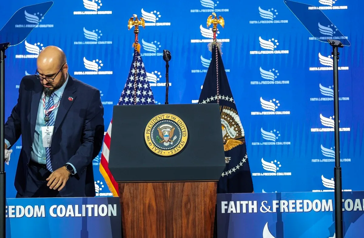 Bărbat la un pupitru cu sigiliul președintelui SUA, pe scena Faith & Freedom Coalition