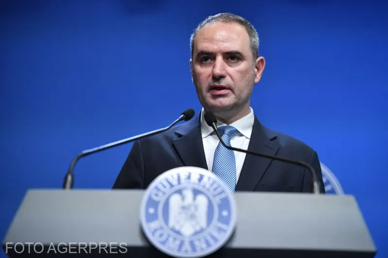 Alexandru Nazare vorbind la pupitrul Guvernului României, pe fundal albastru