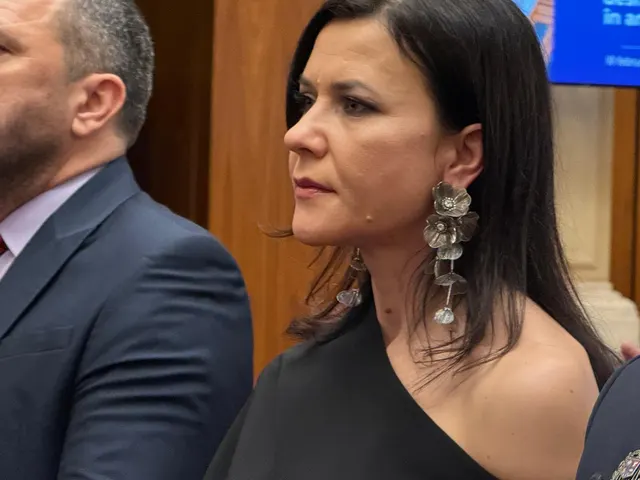 Cristina Chiriac, cu părul negru și cercei mari, alături de un bărbat în costum