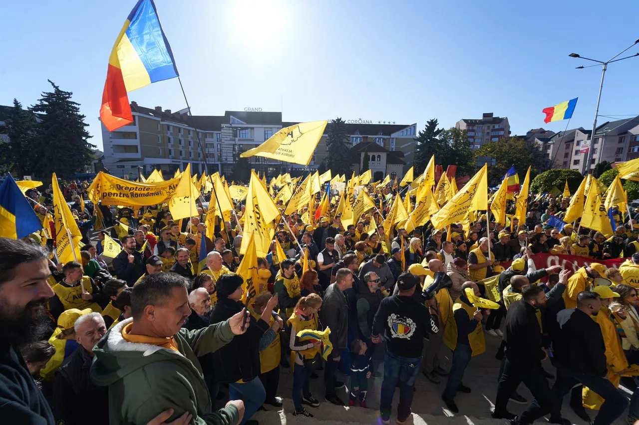 Mulțime cu steaguri galbene la un miting AUR din Bistrița-Năsăud, cu un tricolor ridicat deasupra