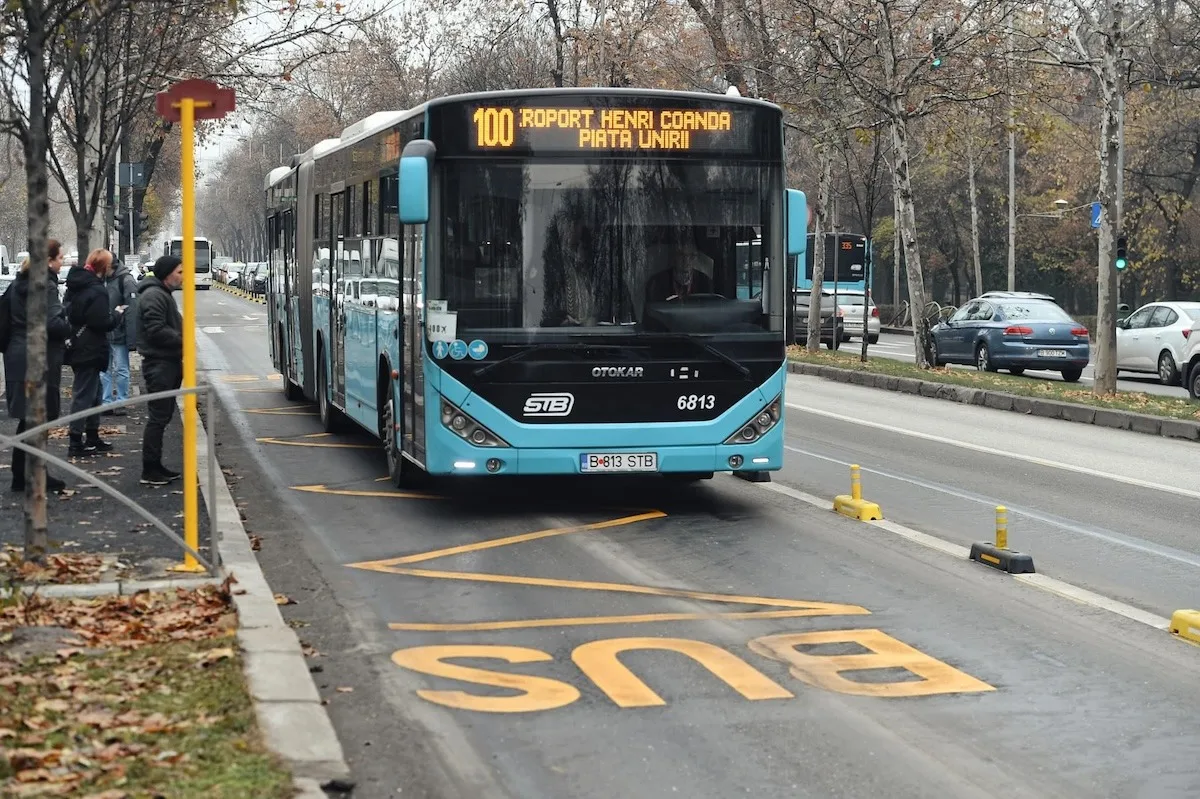 Autobuz STB pe linia 100, pe banda dedicată marcată „BUS”, lângă o stație