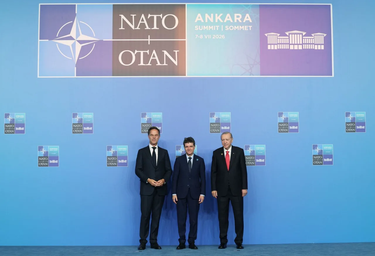 Trei bărbați în costume, pe scenă, sub panoul summitului NATO de la Ankara