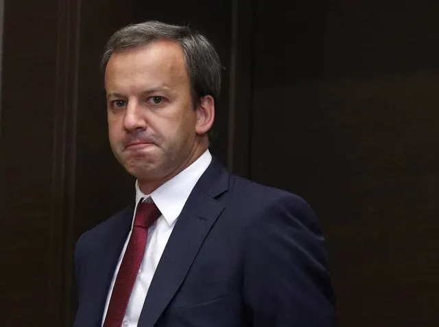 Arkadi Dvorkovich, în costum și cravată roșie, pe un fundal întunecat
