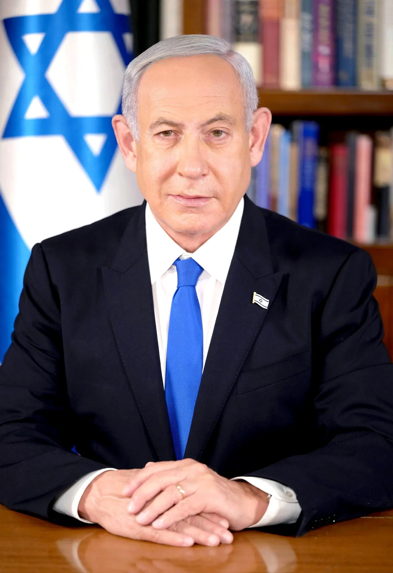 Benjamin Netanyahu, așezat la un birou, lângă drapelul Israelului, în februarie 2023