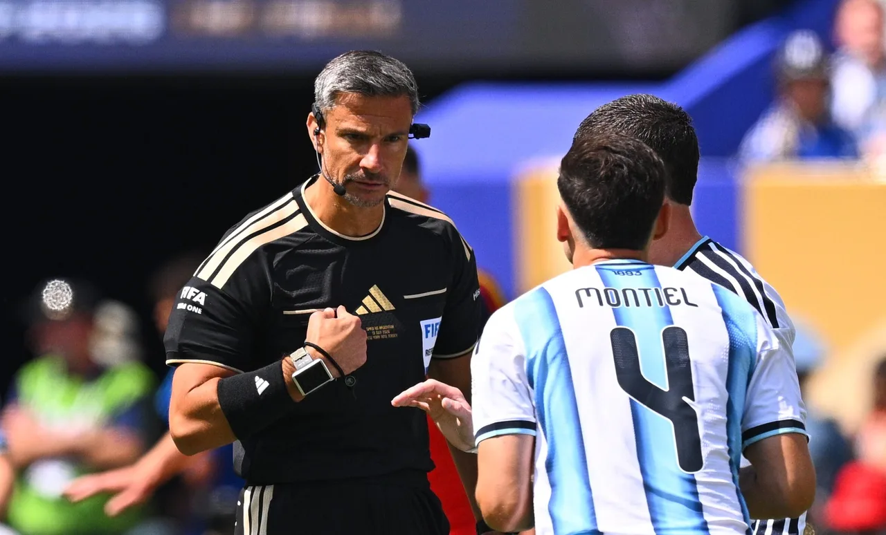 Arbitru în echipament negru vorbind cu un jucător al Argentinei care poartă numele Montiel și numărul 4