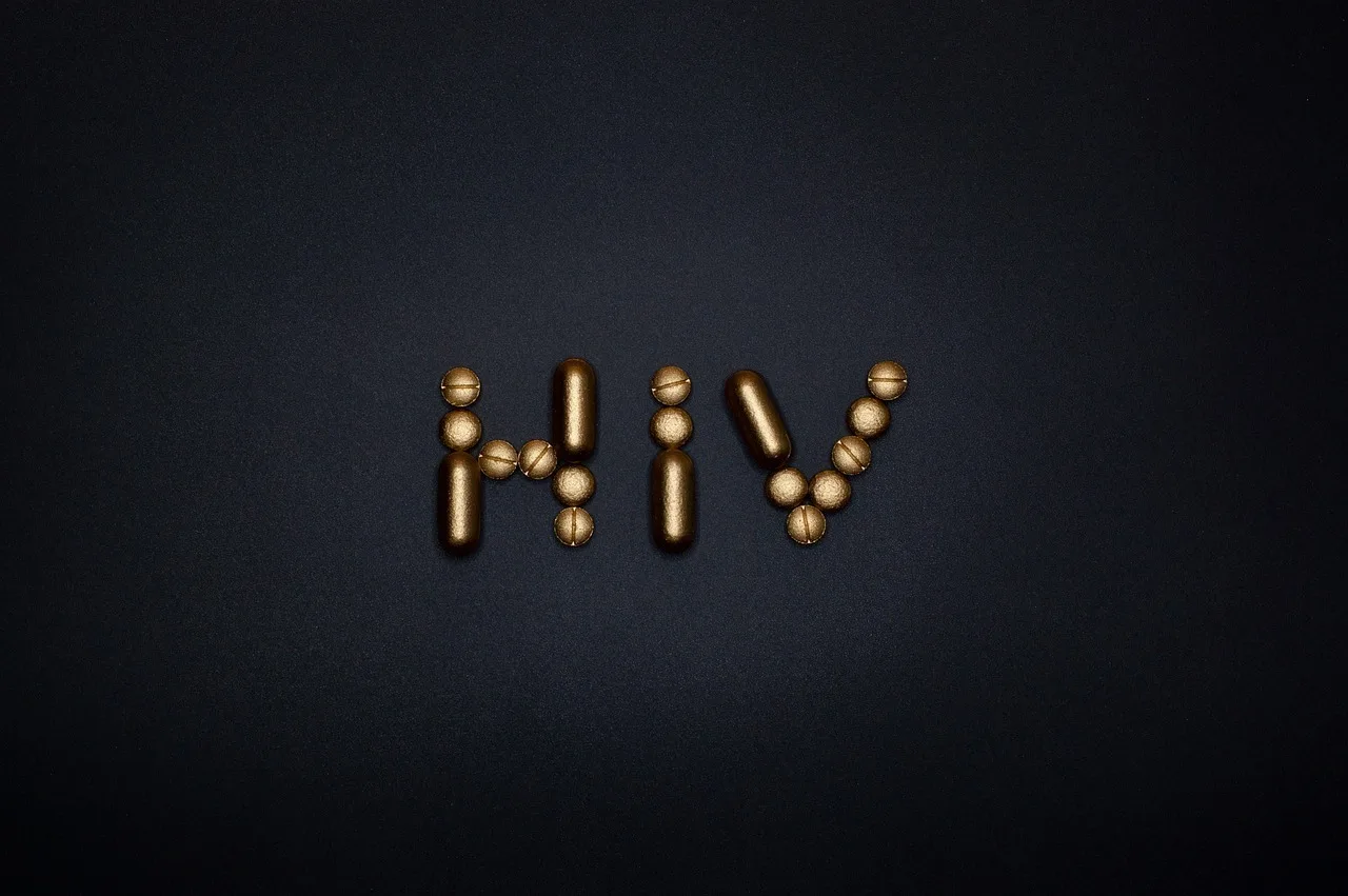 Literele HIV formate din capsule aurii, pe un fundal întunecat