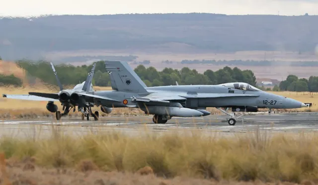 Avioane de vânătoare F-18 ale Forțelor Aeriene Spaniole pe o pistă, într-un peisaj arid