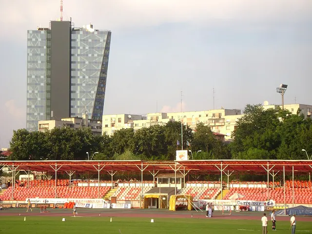Stadionul Dinamo din București, cu tribunele roșii și un bloc înalt în fundal, în iulie 2010