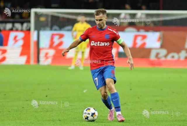 Fotbalist în echipamentul roș-albastru al FCSB, cu sponsorul Betano, conducând mingea pe gazon