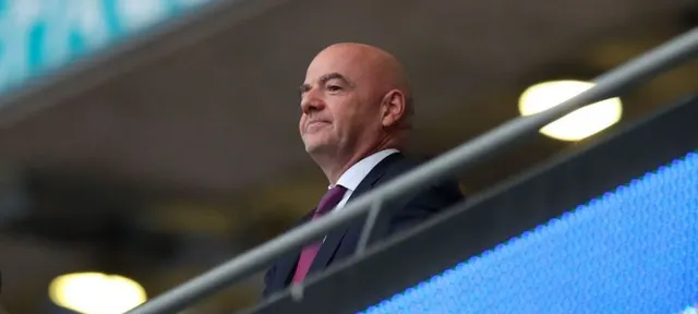 Gianni Infantino, în costum, sprijinit de balustrada unei loje de stadion