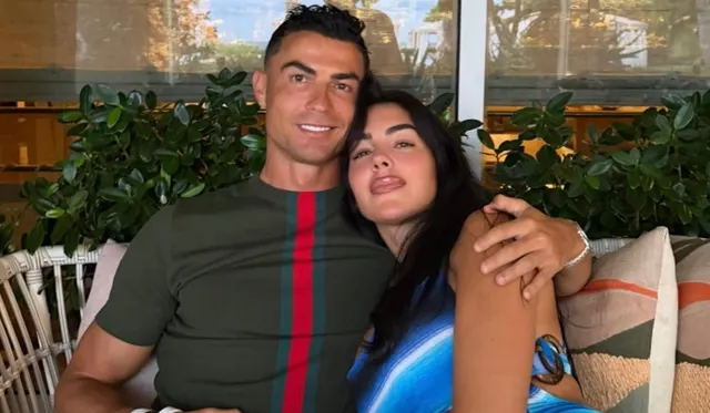 Cristiano Ronaldo și Georgina Rodríguez, îmbrățișați pe o canapea, în fața unor plante