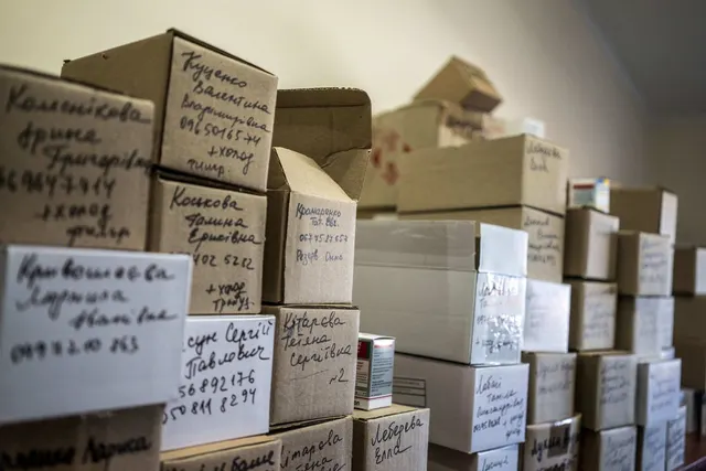Cutii de carton stivuite, cu etichete scrise de mână în chirilică