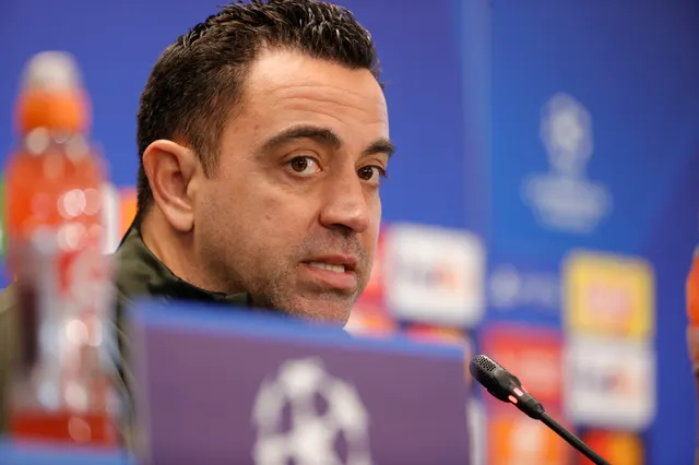Xavi Hernández la o conferință de presă, în fața unui panou cu siglele Ligii Campionilor
