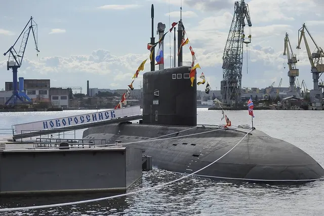 Submarinul „Novorossiisk”, acostat într-un port cu macarale, cu numele scris pe chei