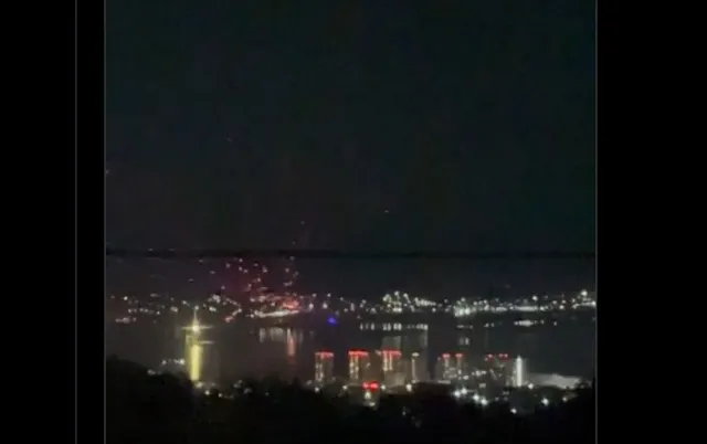Port luminat noaptea, văzut de pe o înălțime, peste apă