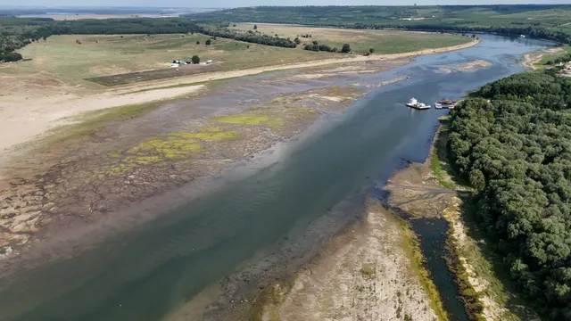 Vedere aeriană asupra unui fluviu cu apă puțină, cu bancuri de nisip și maluri descoperite