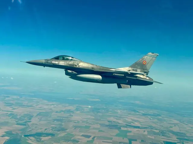 Avion de luptă F-16 cu tricolorul pe derivă, în zbor deasupra câmpurilor