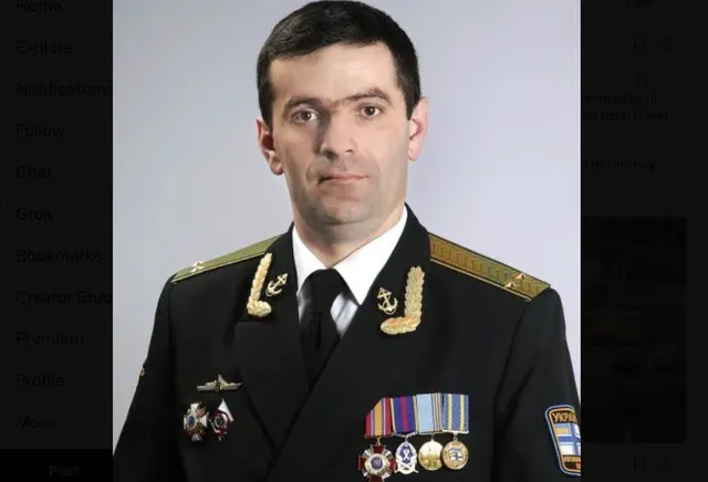 Ofițer de marină în uniformă neagră cu decorații, pe fundal alb
