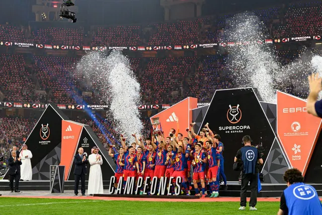 Jucători în echipamentul Barcelonei sărbătorind pe podium, sub inscripția „Campeones”, la Supercupa Spaniei