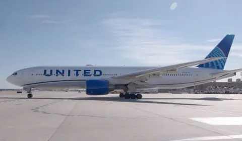 Avion de linie United Airlines pe platforma unui aeroport, sub cer senin