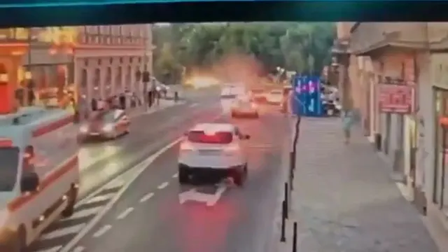 Captură video: o mașină albă rulând pe o stradă îngustă, cu clădiri vechi