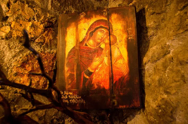 Icoană a Maicii Domnului cu Pruncul, așezată într-o nișă de piatră, luminată cald