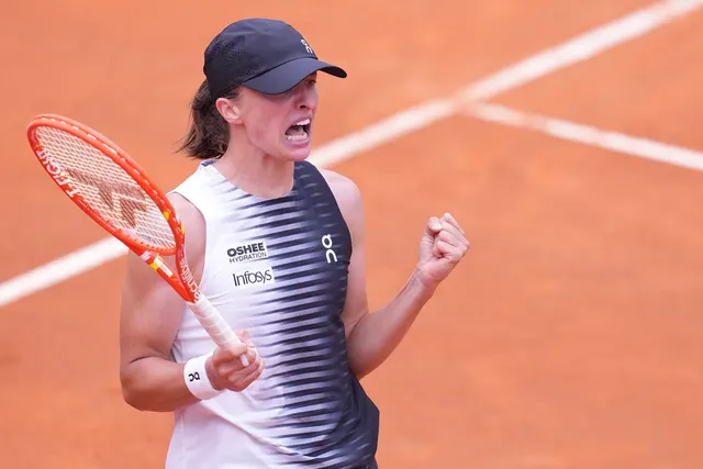 Jucătoare de tenis cu șapcă, strângând pumnul pe un teren de zgură