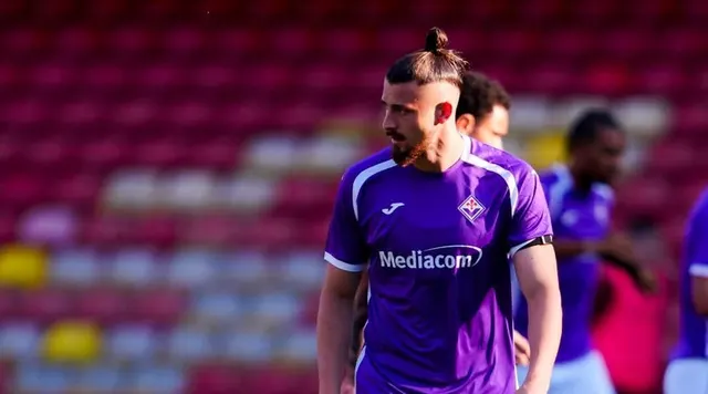 Fotbalist cu barbă și coc, în echipamentul violet al Fiorentinei, cu sponsorul Mediacom