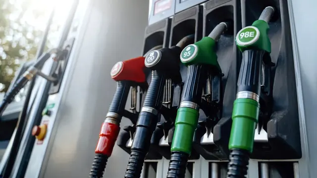 Pistoale de alimentare roșu, negru și verde la o pompă, cu etichetele 95 și 98E