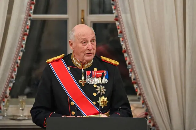 Bărbat în vârstă, în uniformă militară de gală cu eșarfă roșie și decorații, vorbind