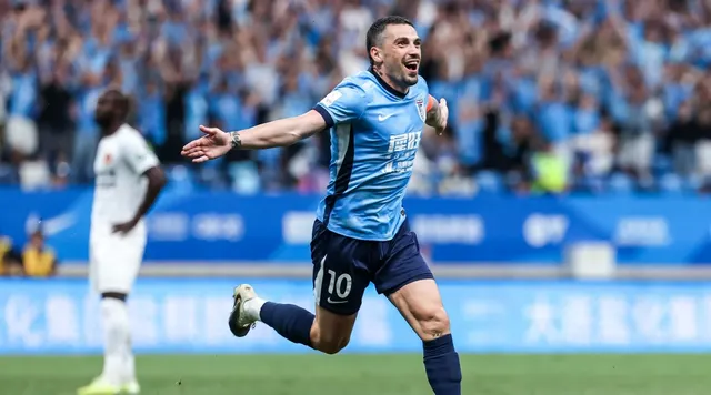 Fotbalist în echipament albastru-deschis, cu numărul 10, alergând cu brațele deschise