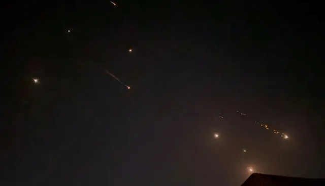 Cer de noapte brăzdat de urmele luminoase ale unor rachete și interceptări