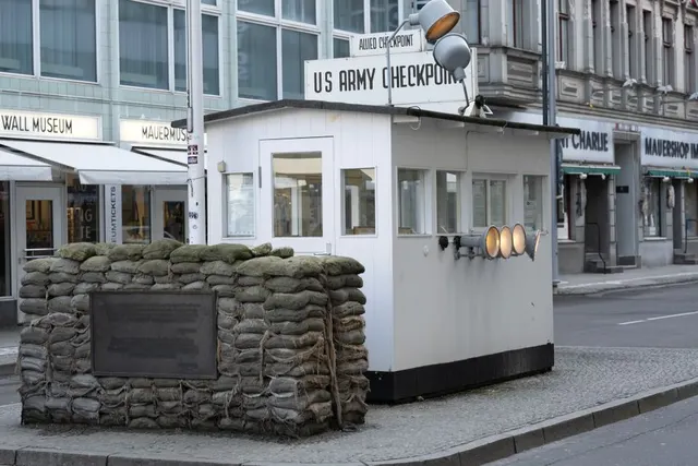Punctul de control Checkpoint Charlie din Berlin, cu saci de nisip și inscripția „US Army Checkpoint”