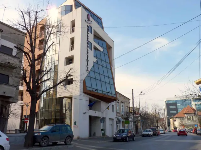Sediul Nuclearelectrica, o clădire de birouri cu fațadă de sticlă, la o intersecție