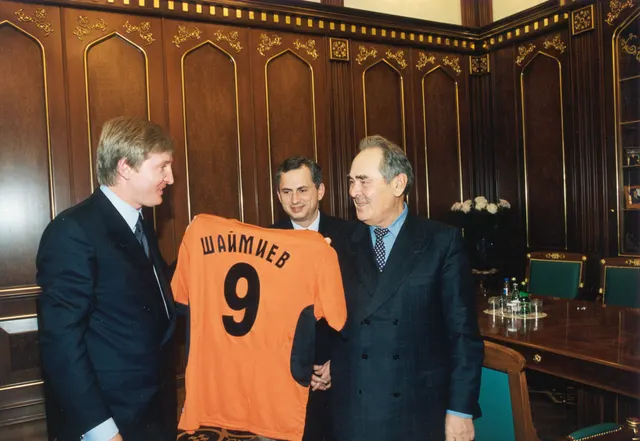 Întâlnirea lui Rinat Ahmetov cu Mintimer Șaimiev, în 2002: trei bărbați țin un tricou portocaliu cu numărul 9