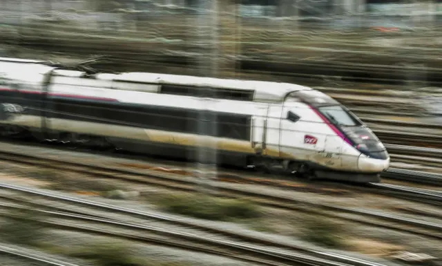 Tren de mare viteză alb în mișcare, fotografiat cu efect de viteză pe șine
