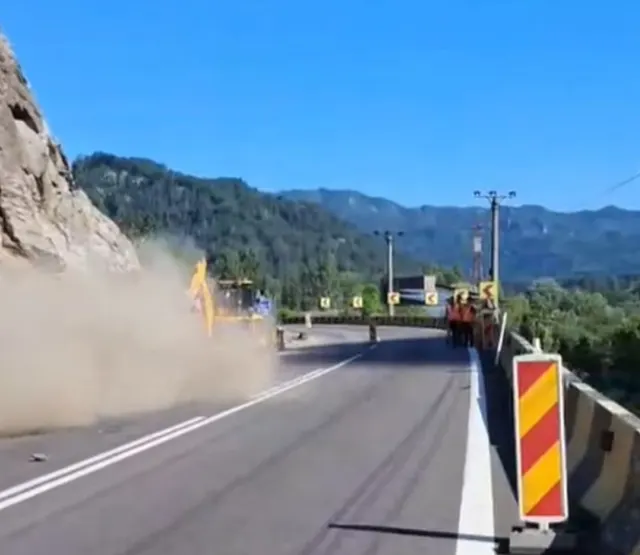 Lucrări de consolidare pe Valea Oltului: praf deasupra drumului, lângă un versant stâncos