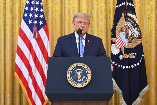 Donald Trump la pupitrul cu sigiliul președintelui SUA, între drapelul american și cel prezidențial