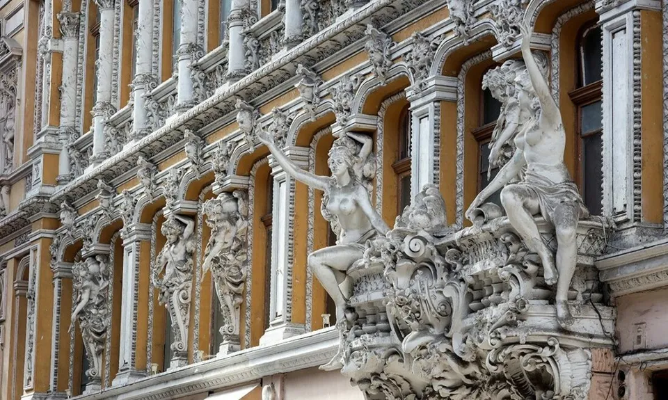 Fațadă bogat ornamentată, cu statui, coloane și balcoane sculptate