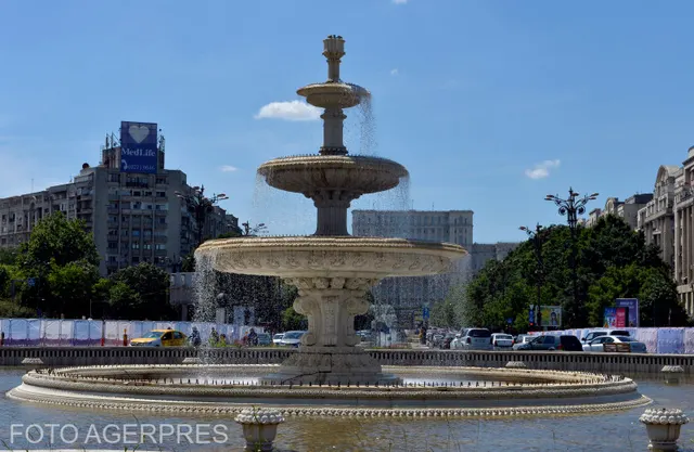 Fântână arteziană cu mai multe etaje într-o piață, cu clădiri înalte în fundal
