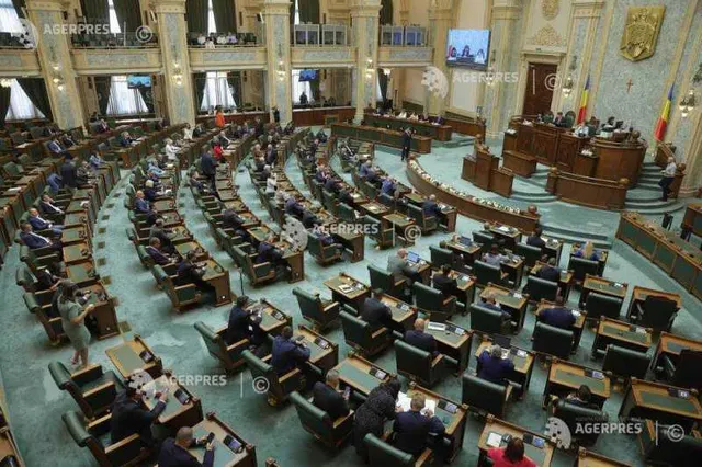 Sală de plen cu mochetă verde și parlamentari în bănci, văzută de sus