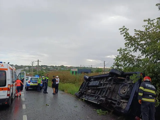 Microbuz răsturnat pe marginea drumului, cu o ambulanță, polițiști și un pompier lângă el