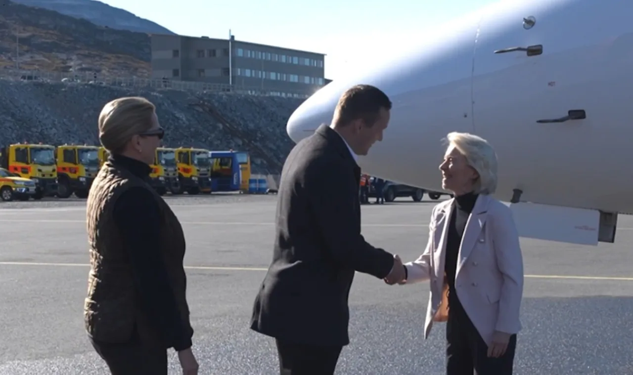 Femeie blondă în jachetă deschisă dând mâna cu un bărbat în costum, lângă un avion, pe un aeroport cu munți