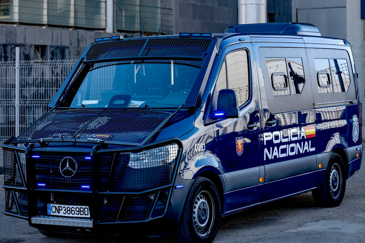 Dubă albastră a Poliției Naționale spaniole, cu inscripția „Policía Nacional”, parcată pe stradă