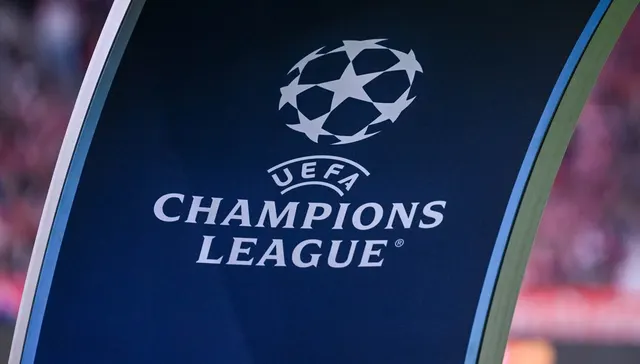 Sigla UEFA Champions League, cu mingea cu stele, pe un panou albastru închis