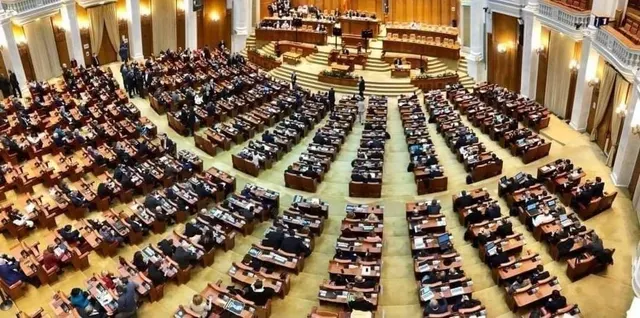 Sală de plen văzută de sus, cu parlamentari așezați pe rânduri de bănci în semicerc