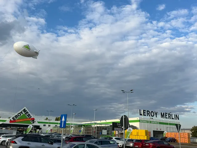 Magazinul Leroy Merlin din Brăila, cu parcarea plină și un dirijabil publicitar pe cer