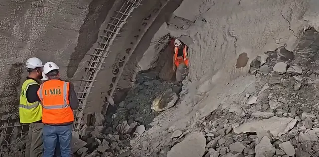 Doi muncitori cu căști și veste reflectorizante în tunelul în lucru de la Margina-Holdea